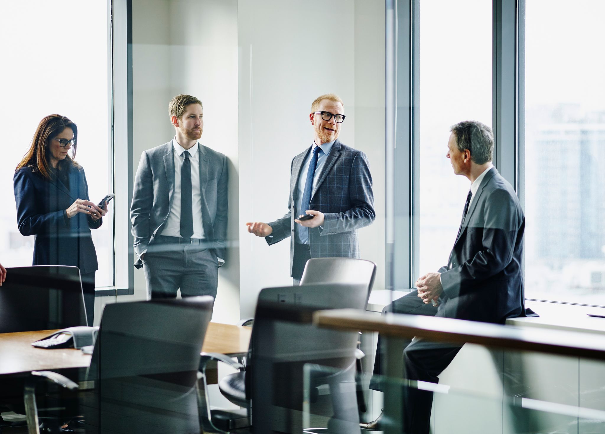 Empowering Decisions with Mergers and Acquisitions Insurance | Group in a conference room, discussing secure deals and risk management.