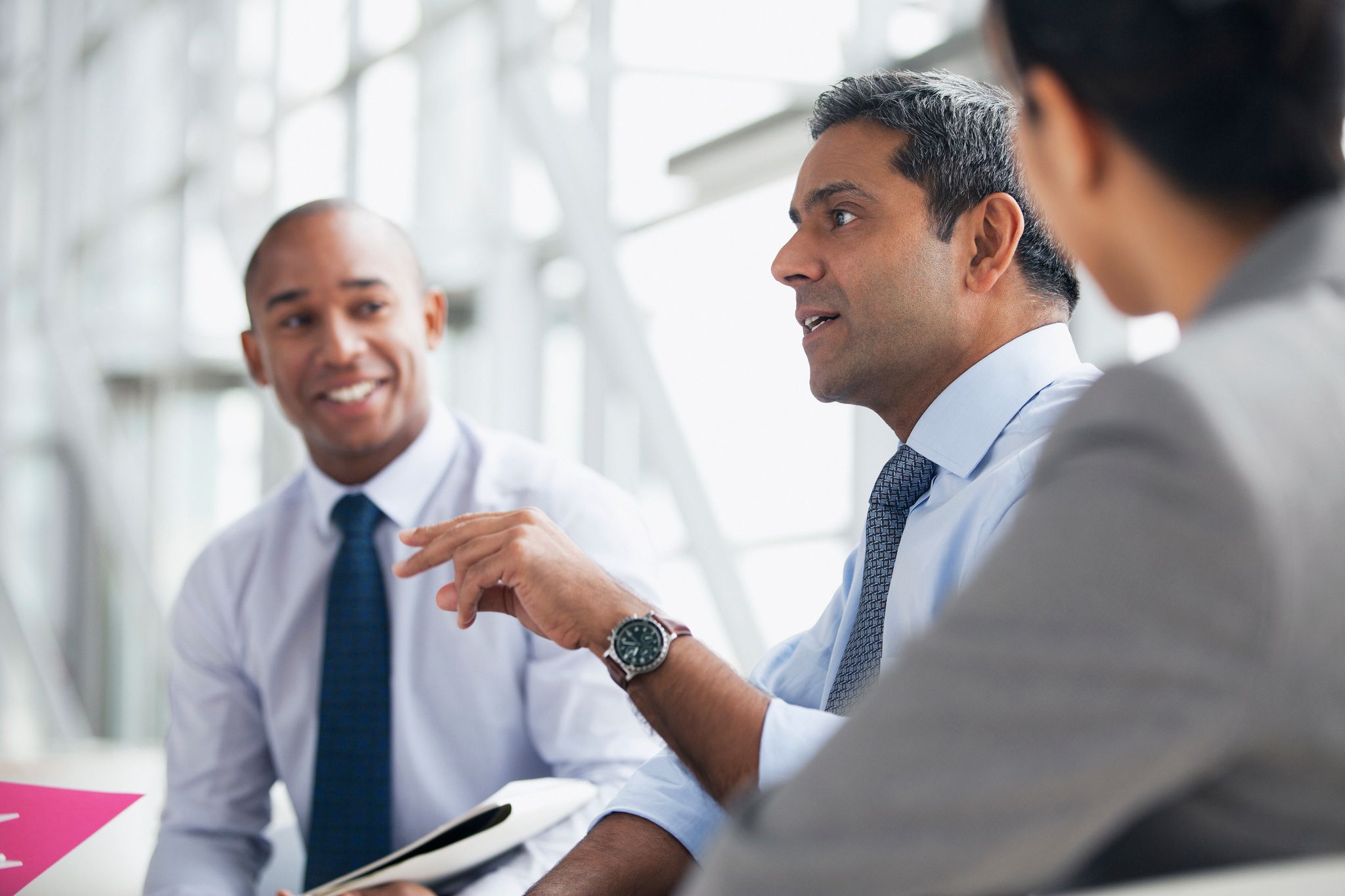 Strategic Planning with Mergers and Acquisitions Insurance | Businessmen in a conference room, discussing secure deals and risk management.